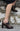 Burgundy patent leather Mary Jane pumps with black lacing and floral embroidery.