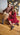 Two people in vintage dresses and Knee boots sitting casually on a wooden floor.